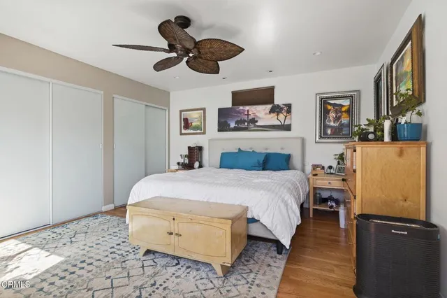 a spacious bedroom with a bed and wooden floor