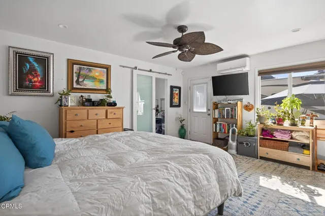 a bed room with a bed a television and a large window