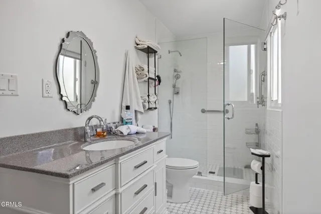 a bathroom with a granite countertop sink toilet and shower