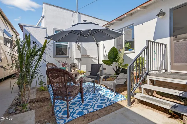 a view of a patio with table and chairs under an umbrella