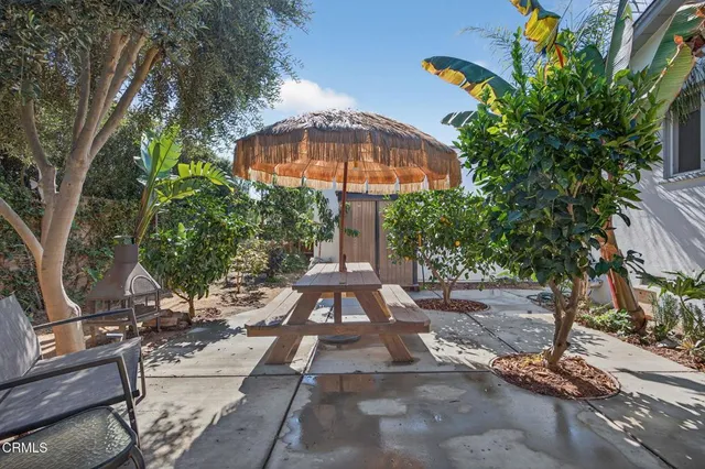 a view of a patio with a table and chairs under an umbrella
