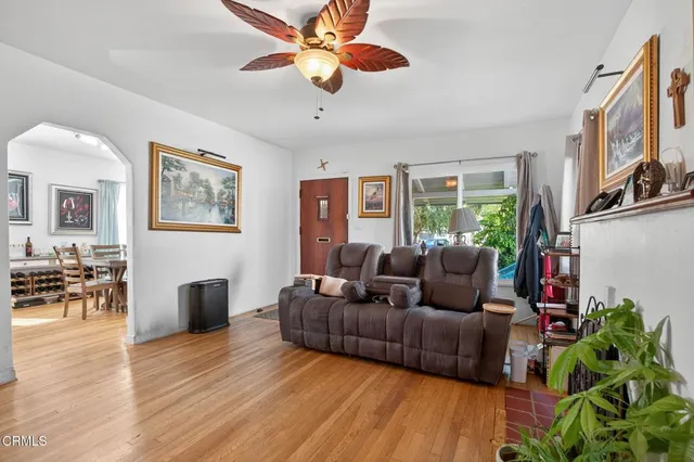 a living room with furniture and a wooden floor