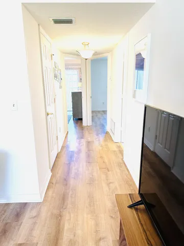 a view of a hallway with wooden floor and staircase