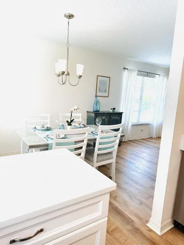 a room with stainless steel appliances kitchen island granite countertop a sink dishwasher and white cabinets with wooden floor