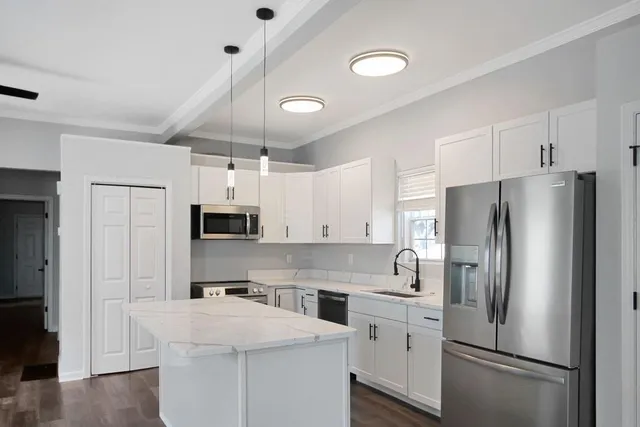 a kitchen with stainless steel appliances a refrigerator sink and microwave