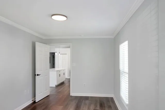 a view of empty room with wooden floor and window