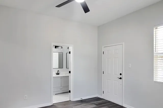 a view of a hallway with wooden floor and windows