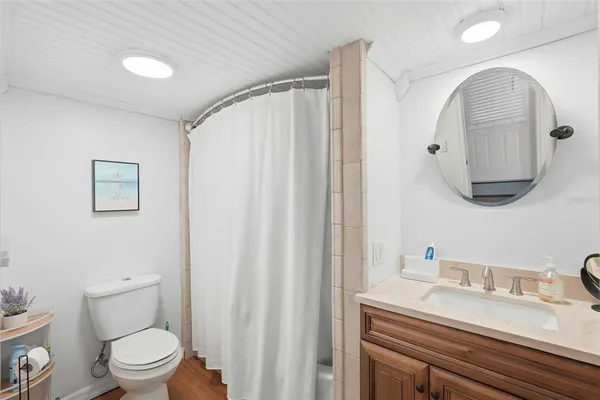 a bathroom with a granite countertop sink a toilet and a mirror