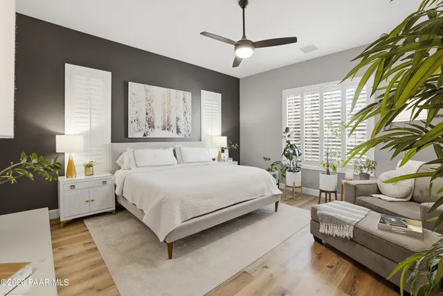a spacious bedroom with a bed a couch and a chandelier