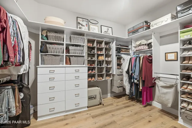 a view of walk in closet with clothes and shoes