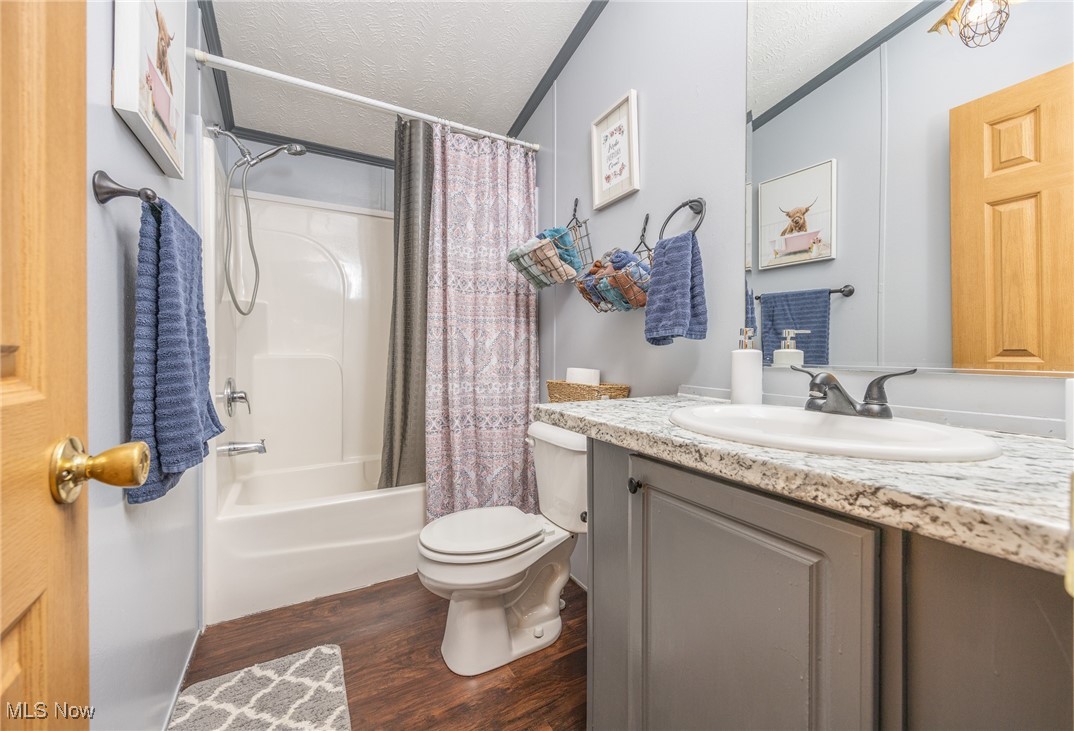 1788 Rosenbush Road Newport, OH 45768 - Photo 28 of 34 Full bathroom featuring a textured ceiling, shower / bath combination with curtain, dark wood-style floors, and vanity