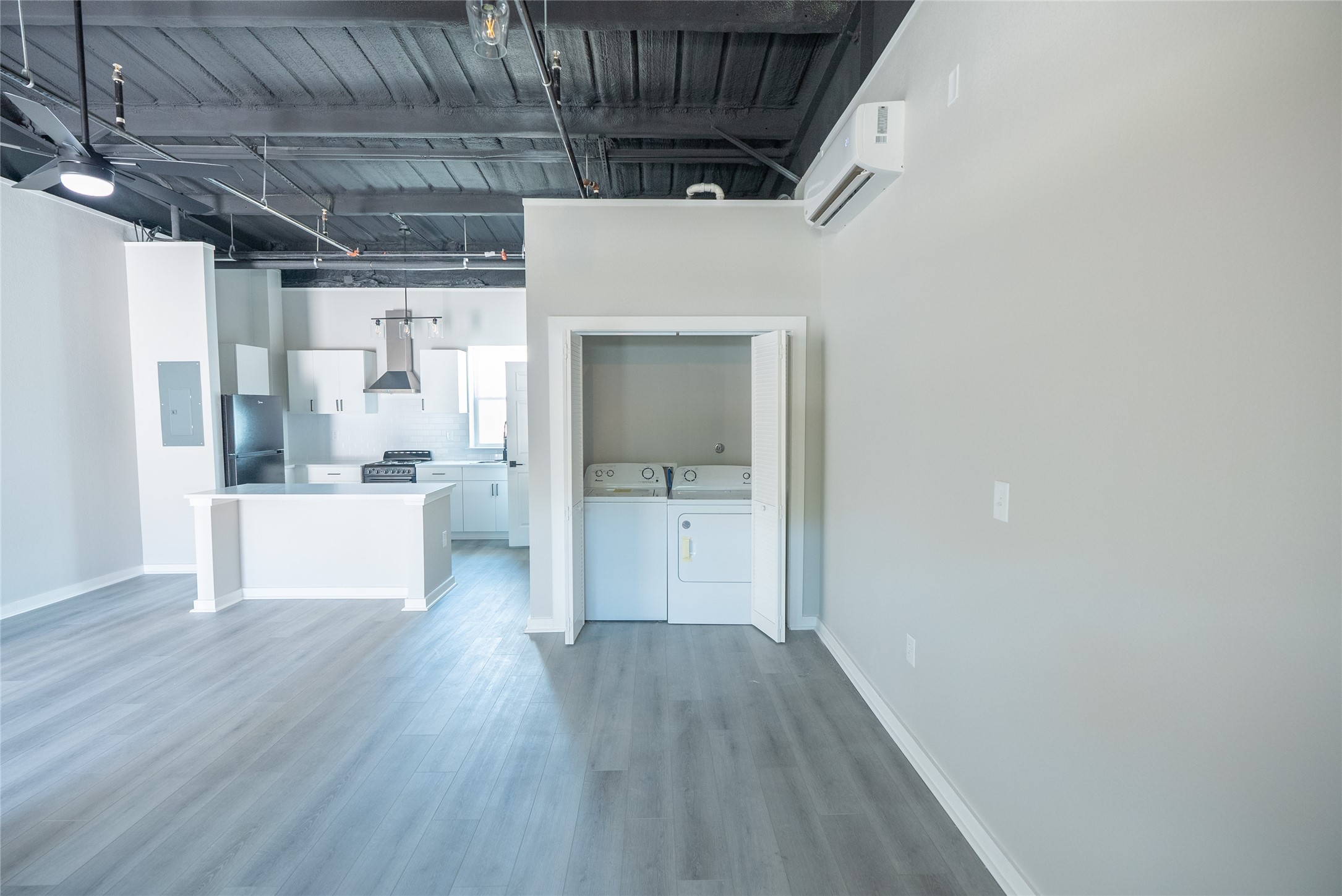 2612 Castle Street, Unit H Waller, TX 77484 - Photo 6 of 11 a view of a hallway with wooden floor and a kitchen