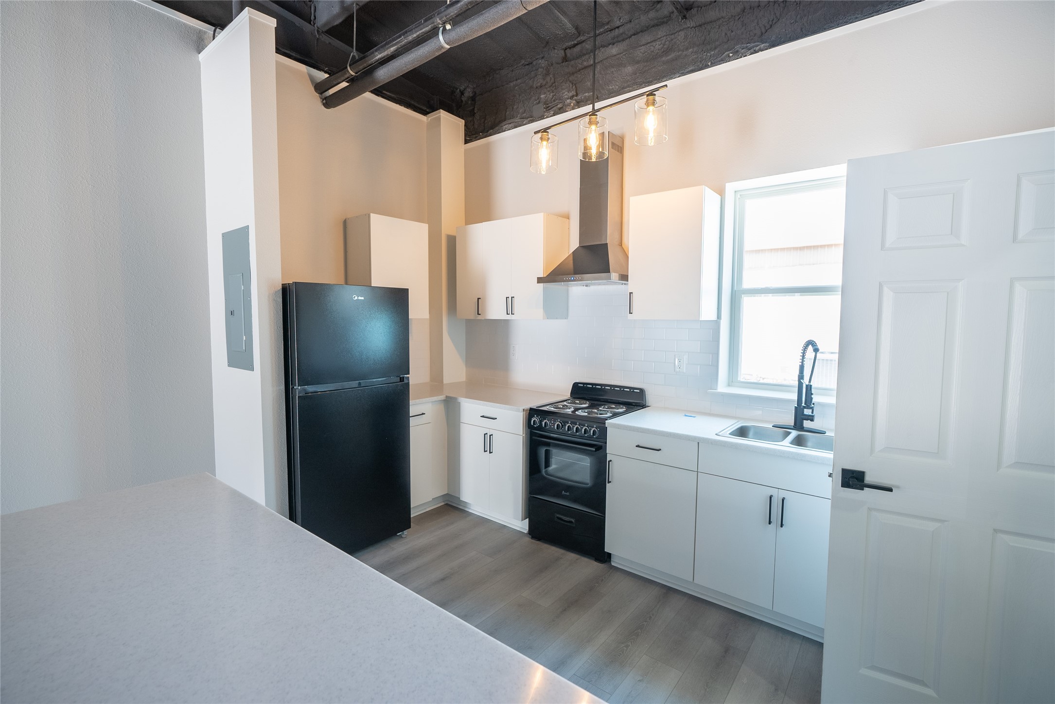 2612 Castle Street, Unit H Waller, TX 77484 - Photo 7 of 11 a kitchen with stainless steel appliances granite countertop a refrigerator a sink a stove and a refrigerator with wooden floor