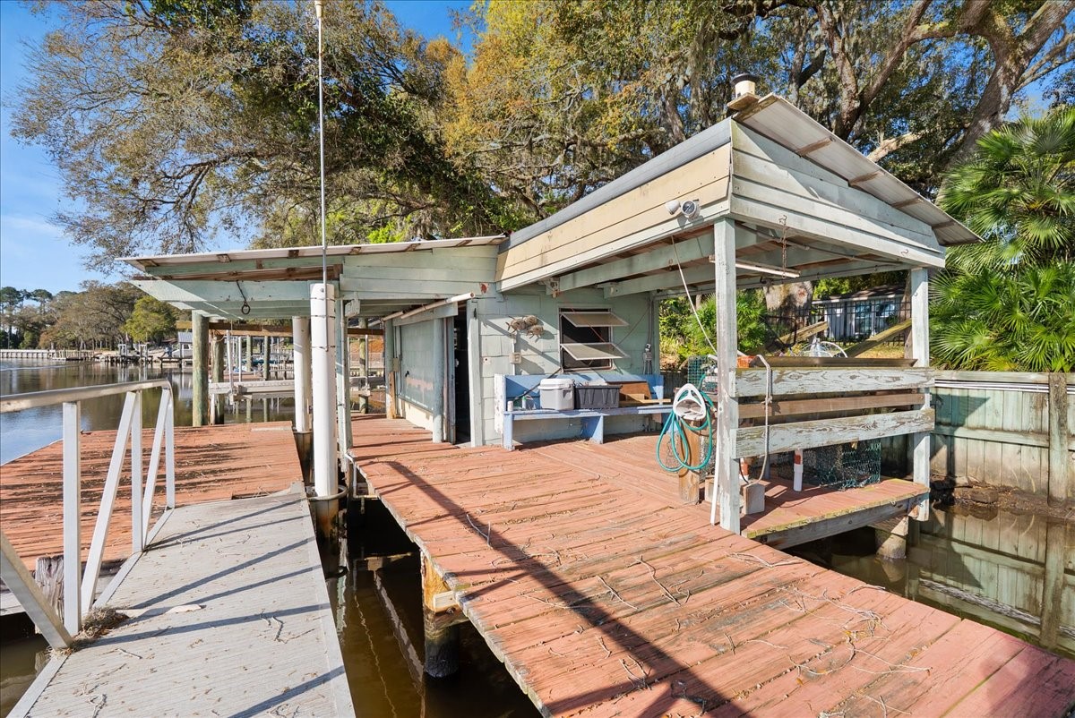 85316 Avant Road Yulee, FL 32097 - Photo 55 of 62 a view of a patio with table and chairs under an umbrella with large trees