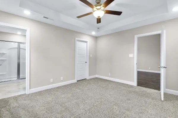 an empty room with closet and a chandelier fan