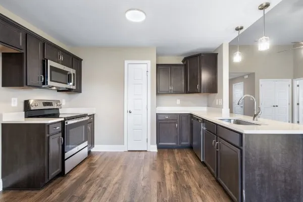 a kitchen with stainless steel appliances granite countertop a stove a sink and a microwave