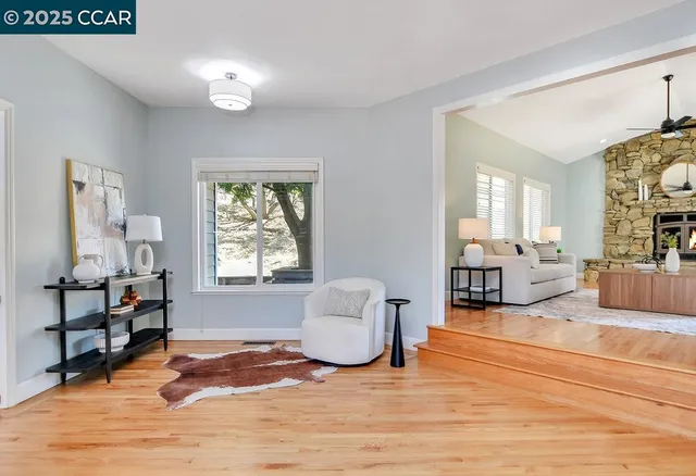 a living room with furniture a fireplace and a chandelier