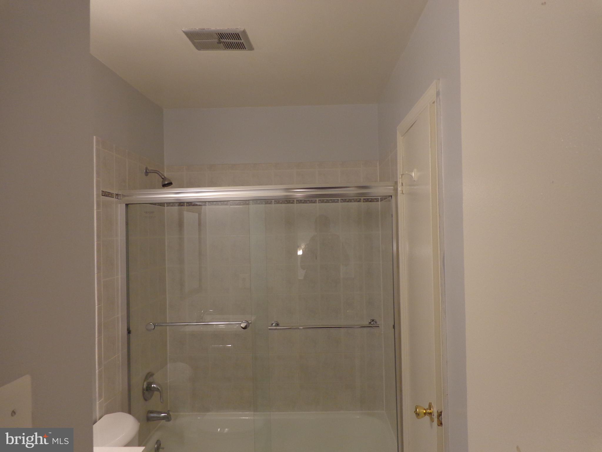 5565 Peppercorn Drive Burke, VA 22015 - Photo 30 of 41 a bathroom with a glass shower door