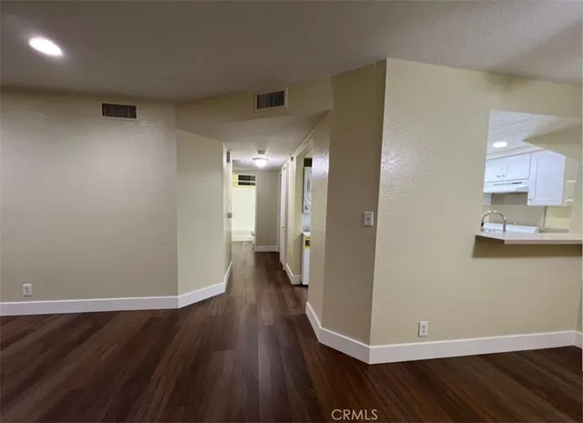 a view of a room with wooden floor and a sink