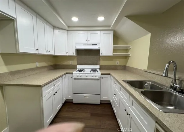 a kitchen with sink cabinets and stove top oven