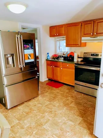 a kitchen with stainless steel appliances granite countertop a stove a sink and a refrigerator
