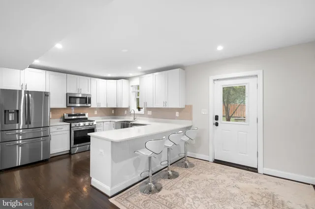 a kitchen with stainless steel appliances a stove a sink and a refrigerator