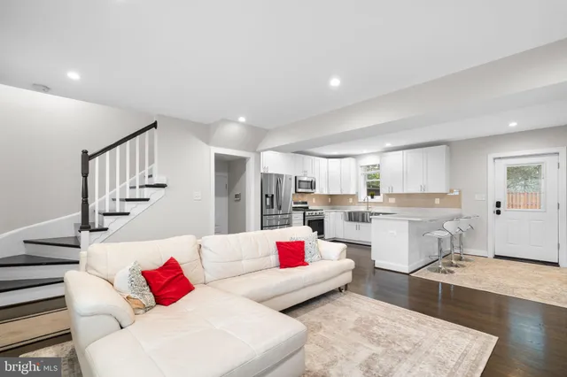 a living room with furniture kitchen view and a couch