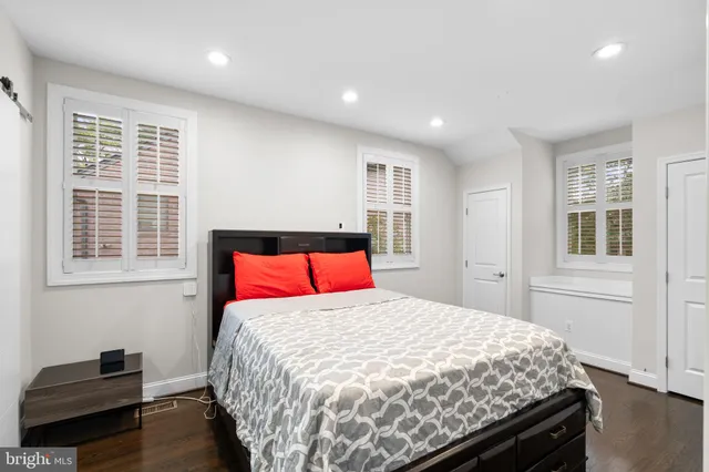 a bedroom with a large bed and wooden floor