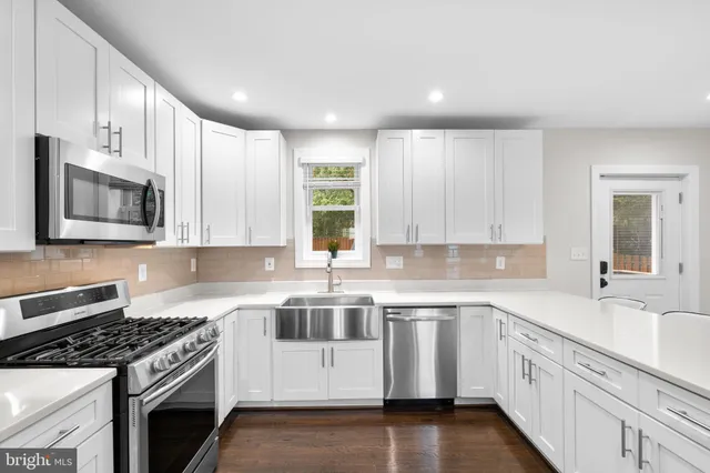a kitchen with granite countertop white cabinets and stainless steel appliances