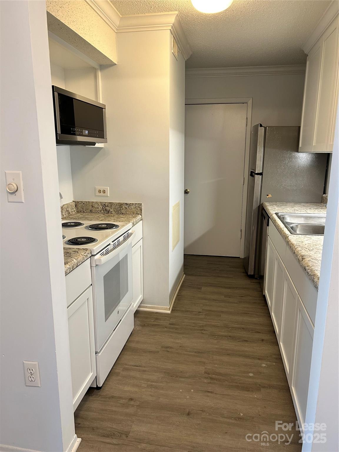 4936 Sardis Road, Unit A Charlotte, NC 28270 - Photo 5 of 21 a kitchen with a stove and a microwave