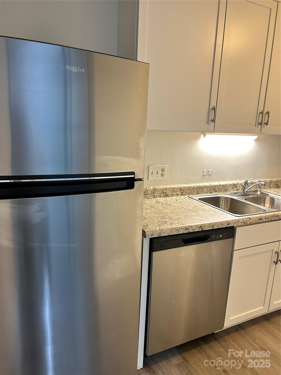 4936 Sardis Road, Unit A Charlotte, NC 28270 - Photo 8 of 21 a view of a refrigerator in kitchen and wooden floor