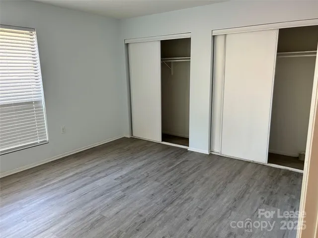 an empty room with wooden floor and a window