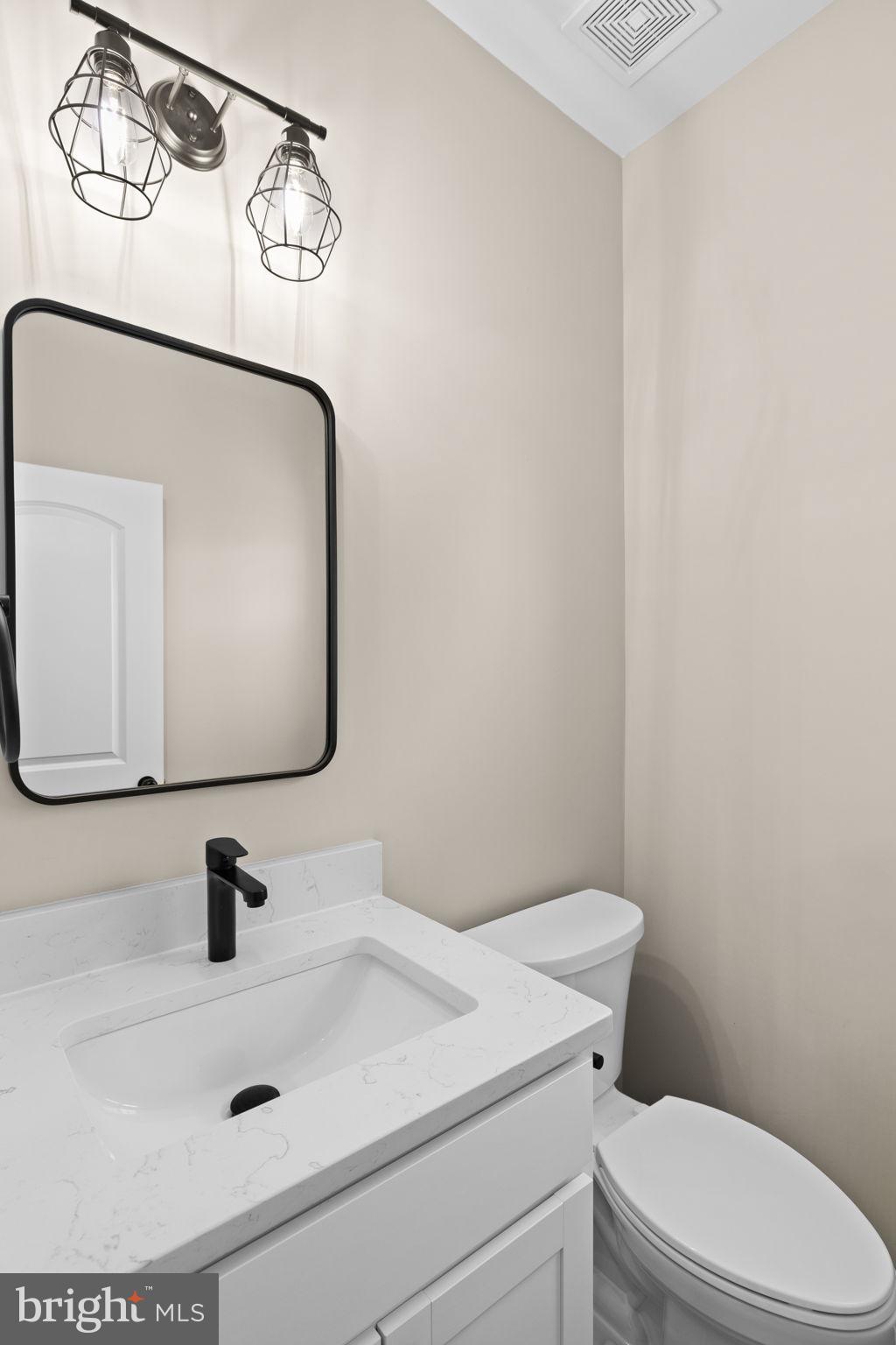5835 Smith Station Road Fredericksburg, VA 22407 - Photo 12 of 31 a bathroom with a sink mirror vanity and toilet