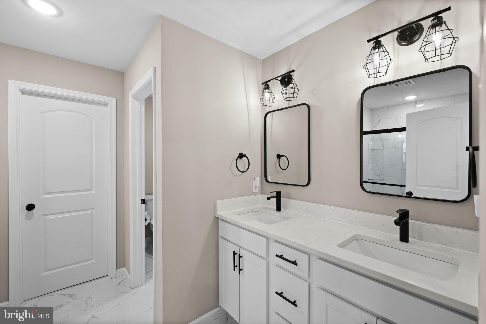 5835 Smith Station Road Fredericksburg, VA 22407 - Photo 22 of 31 a bathroom with double vanity sinks and a mirror
