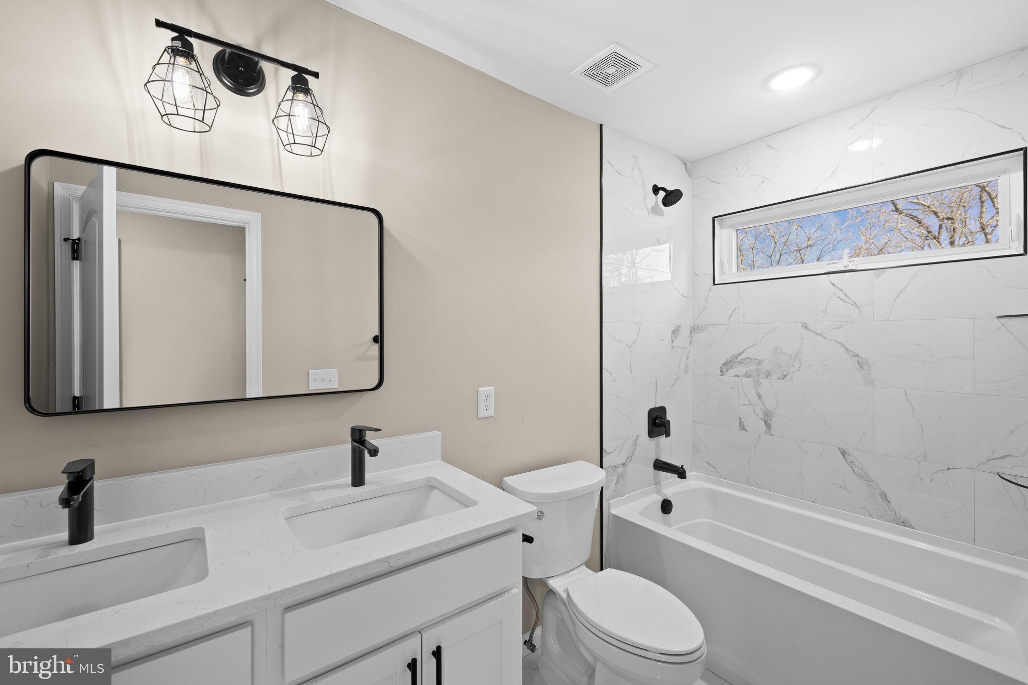 5835 Smith Station Road Fredericksburg, VA 22407 - Photo 28 of 31 a bathroom with a toilet sink vanity tub and mirror