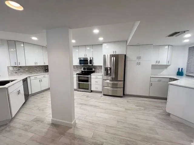 a kitchen with granite countertop a refrigerator and a sink