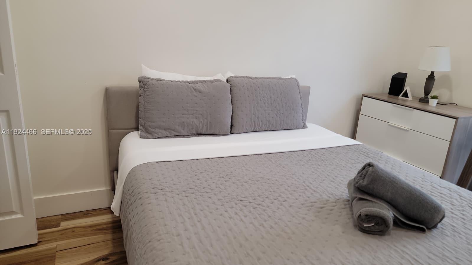 2820 Southwest 13th Street, Unit 4 Miami, FL 33145 - Photo 2 of 17 a bedroom with a bed and a chair