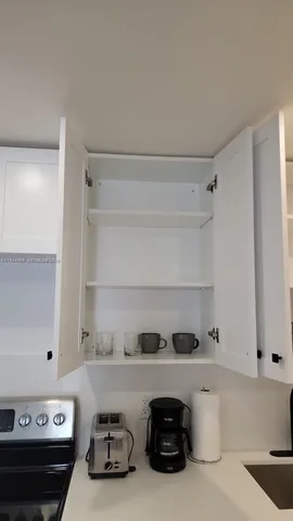 a kitchen with a sink a stove and cabinets