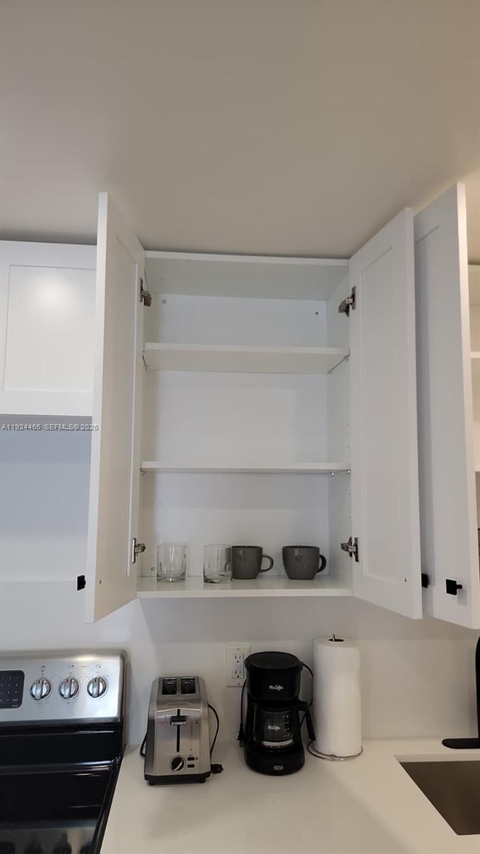 2820 Southwest 13th Street, Unit 4 Miami, FL 33145 - Photo 3 of 17 a kitchen with a sink a stove and cabinets