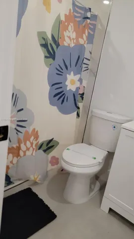 a bathroom with a sink a toilet and a shower curtain