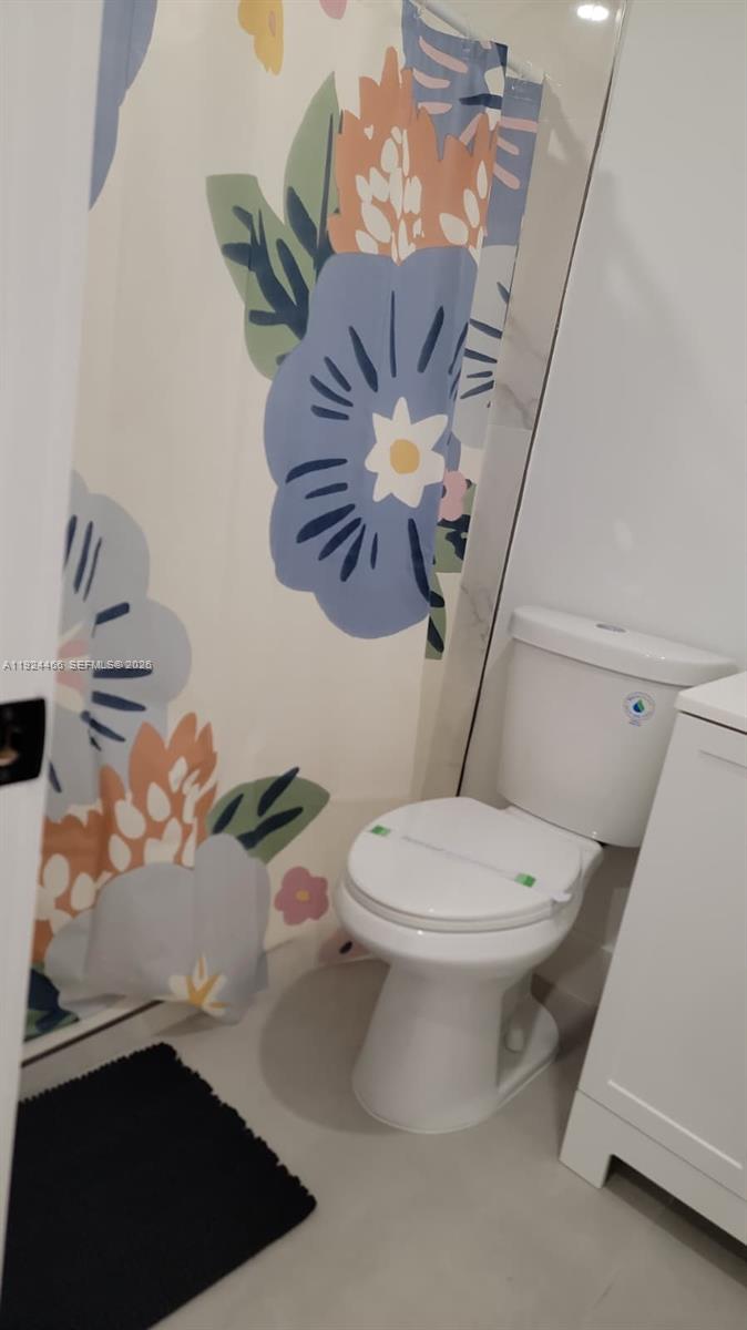 2820 Southwest 13th Street, Unit 4 Miami, FL 33145 - Photo 7 of 11 a bathroom with a sink a toilet and a shower curtain