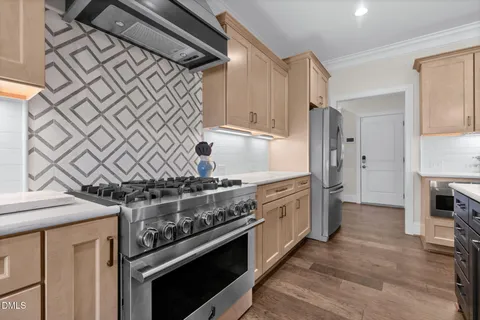 a kitchen with a stove a refrigerator a sink and chairs