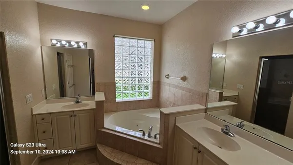 a bathroom with a tub sink and mirror