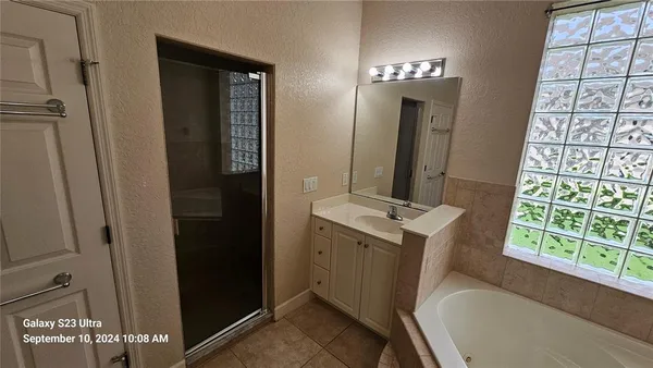 a bathroom with a tub sink and mirror