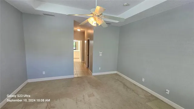a view of an empty room and a fan
