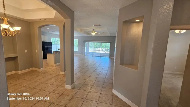 a view of a hallway with wooden floor and a bathroom