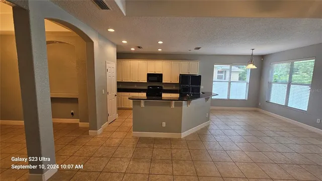 a view of kitchen with stainless steel appliances granite countertop a stove a sink and a refrigerator