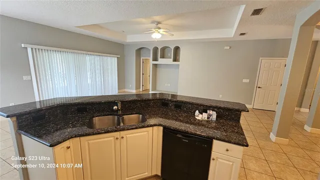 a kitchen with granite countertop a sink and cabinets