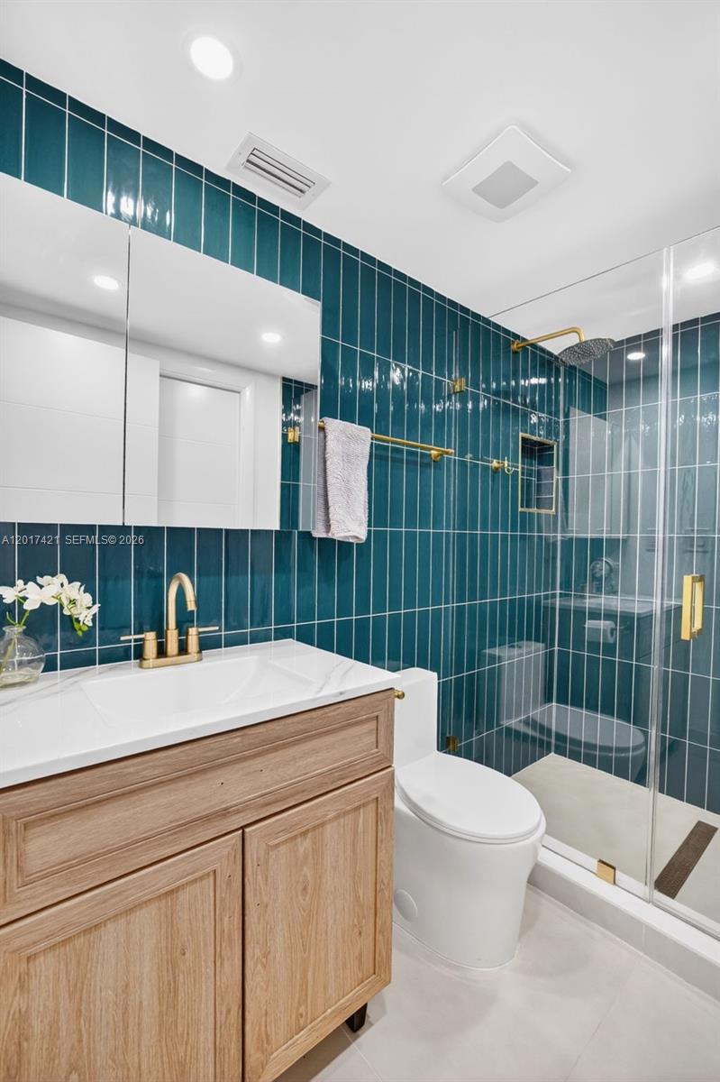 3848 Atlanta Street Hollywood, FL 33021 - Photo 48 of 79 Upstairs guest bathroom (also en suite for one bedroom). Beautiful wall tile and vanity / medicine cabinet. Frameless shower enclosure