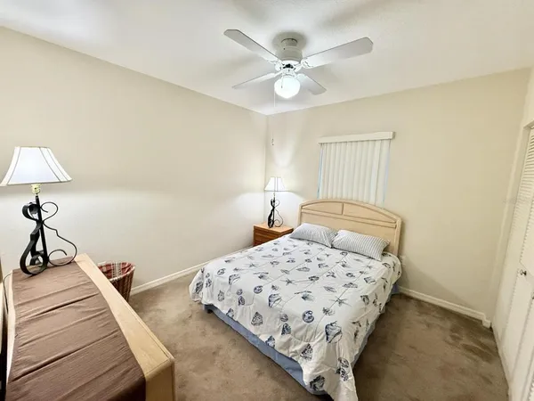 a bedroom with a bed and a lamp on the dresser